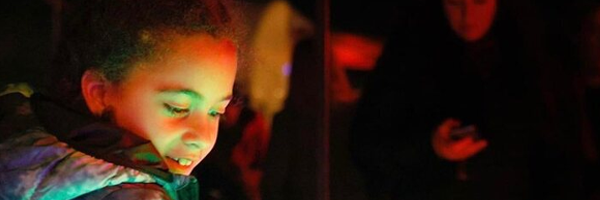child admiring different coloured lights
