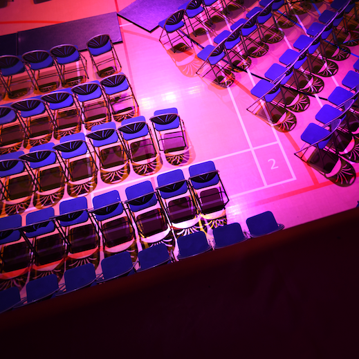 the sports hall at gl1 illuminated in pink and purple lights, being transformed into a performance space
