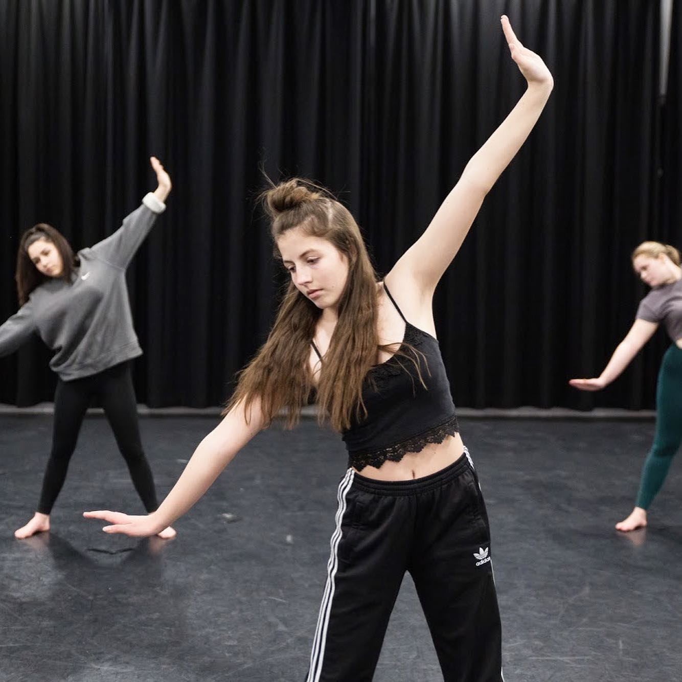 members of Strike A Light Youth Dance Company stretch and warm up in a dance studio